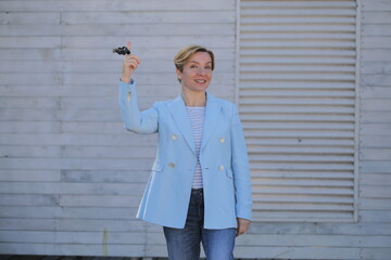 a female realtor stands with the keys to the apartment