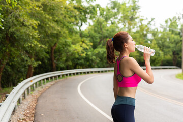  woman drinking water after running