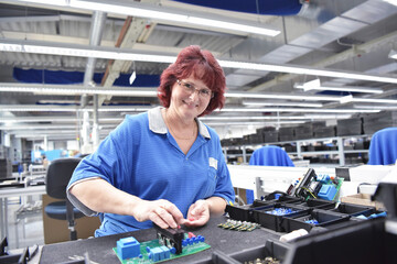 friendly woman working in a microelectronics manufacturing factory - component assembly and...