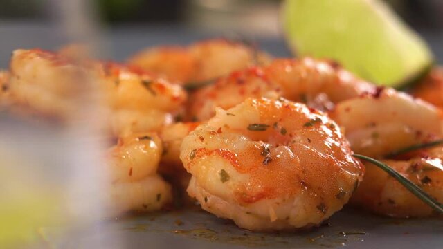 Camera movement of fried prawns in sweet and sour sauce with garlic spices and seasonings. Shrimps is sprinkled with green chopped onions. Macro food background. Seafood