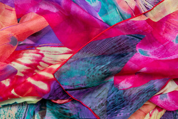 Silk texture. Closeup of a beautifully folded multicolored silk scarf or headscarf with a pattern.