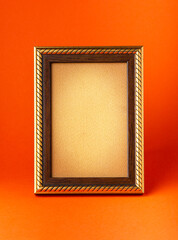 Fototapeta premium Wooden frame with old paper on orange background.