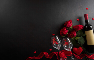 Love and Valentine's day concept made from champagne glasses , wine, red hearts and rose on black wooden background. Top view with copy space, flat lay.