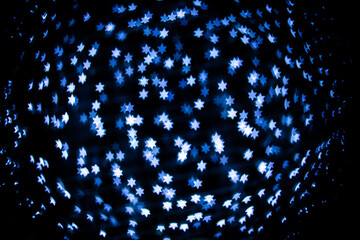 Abstract blue star bokeh on black background.
