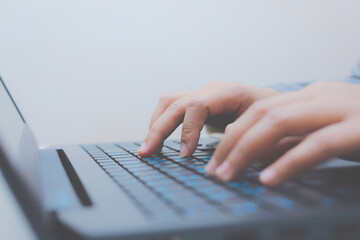 close-up of business woman hand typing and using laptop keyboard for searching with technology networking on working and job on desk at work place or work at home.