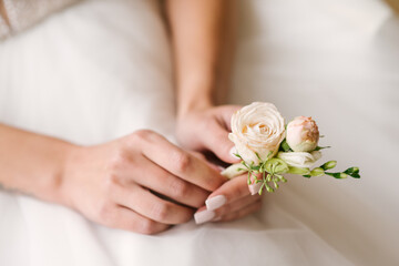 Obraz na płótnie Canvas Close up bride holding buttonhole in hands
