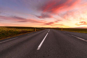 Fototapeta na wymiar Stunning summer sunset over a deserted road through the countryside of Iceland