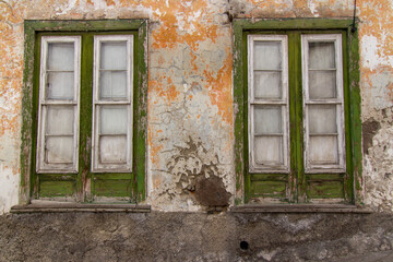 Fototapeta na wymiar Old colorful green windows on a yellow wall
