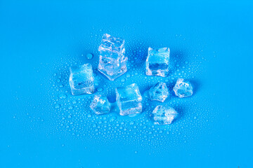 Melting ice for drinks with water drops on a blue background