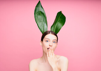 Surprised naked young woman covered her mouth with her hand.
