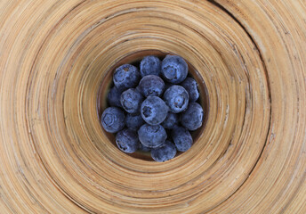 frozen blueberries in a cup on a wooden table