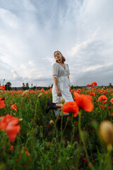 portrait of a girl in a white dress and black shoes in a field of flowers