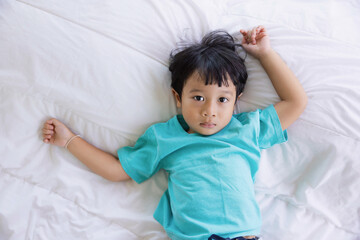 Authentic close up of happy kid in a bed. Concept of new generation, family, parenthood, authenticity, Son.