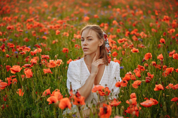 portrait of a girl in a white dress in a field of red poppies