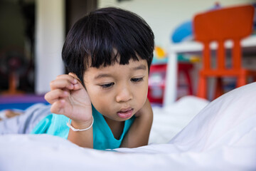 close up of happy boy Playing mobile, Taking pictures or selfie or video call or relatives in a bed. Concept of new generation, family, parenthood, authenticity, connection.