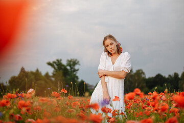 Fototapeta na wymiar portrait of a girl in a field of poppies