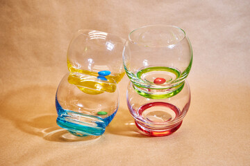 crazy clear whiskey glasses with round colorful bottoms and colorful candies