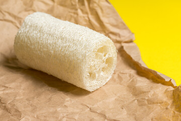 Luffa sponge for zero waste dish washing or bath on a yellow background close-up. eco friendly