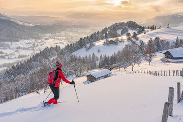 nice active senior woman snowshoeing in the Allgaeu Alps near Oberstaufen with view into the...