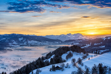 Obraz na płótnie Canvas awesome winter landscape at sunset with view from the Allgau Alps over the Bregenzer Wald in Austria to Mount Saentis in Switzerland