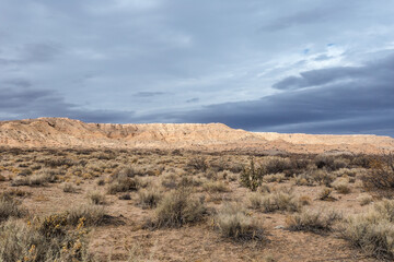 Beautiful blue sky with clouds behind mesa plateau in open desert range on cloudy day in rural New Mexico