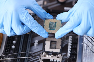 Fototapeta na wymiar Master holds microcircuit over computer boards closeup