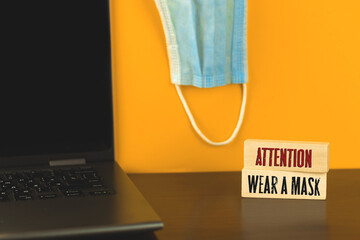 New normal workplace with reminder wear a medical mask, text inscription on a wooden pegs, blocks