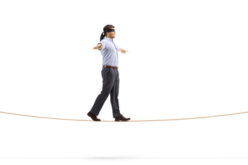 Professional man with blindfold walking on a rope and spreading arms