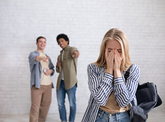 European and african american teens zoomers guys laugh at crying female with backpack in school or...