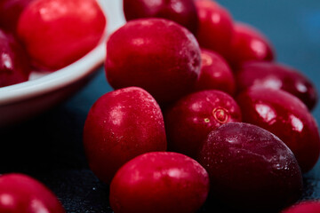 Ripe cornel berries on dark background. Close up