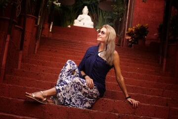 A girl in a beautiful garden and on the background of a buddha