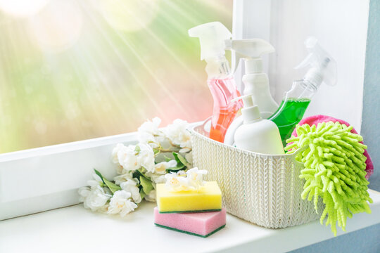 Spring cleaning concept - cleaning supplies and flowers on blur background, copy space
