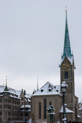 Obraz premium Snow covered old town Zurich with church bell tower winter time cloudy day
