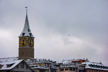 Obraz premium Snow covered old town Zurich with church bell tower winter time cloudy day