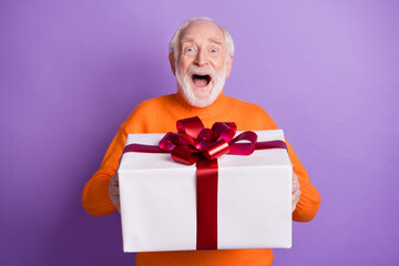 Photo of handsome impressed man open mouth getting unexpected giftbox isolated on violet color...