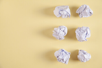 Set of crumpled paper balls, on an isolated yellow background.