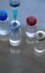 Jeringa que elige uno de los frascos de vacunas. Vaccine election