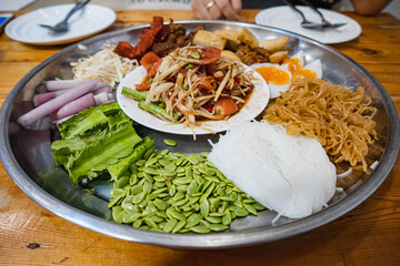 Papaya Salad on tray, with roasted pork, rice noodles, shrimp pork, boiled egg, fried Vietnamese sausage