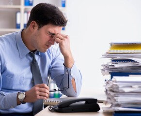 Extremely busy businessman working in office