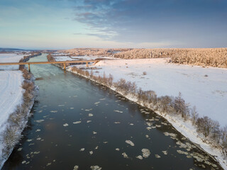 Bridge over the Dnieper River, snowy forest on a beautiful winter day with blue sky and clouds. Beautiful winter landscape