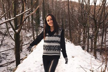 Young caucasian woman playing on a snowy forest.