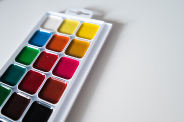 Top view of set of watercolor paints  in a box, isolated on white.