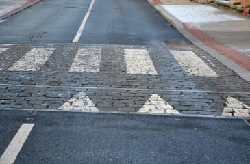 navigation tactile tiles strip for blind and disabled pedestrians who have vision problems. The red pavement has protrusions that lead the person to the crossing and draw attention to the edge road