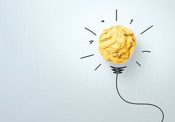Yellow scrap paper ball with illustration painting for virtual lightbulb. It is creative thinking idea and innovation concept. © Dilok