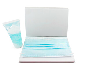 Blue face mask on blank white notebook with alcohol gel for washing hands isolated on white background with clipping path.