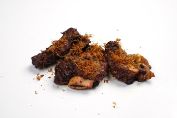 Small pieces of fried ribs that are dark brown in color. The beef ribs have been seasoned, then sprinkled with typical Indonesian spices. Spicy fried ribs. Fried ribs isolated on white background.