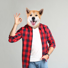 Stylish man with head of dog on grey background