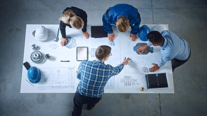 Team of Industrial Engineers Lean on Office Table, Analyze Machinery Blueprints, Architectural...