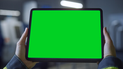 Industry 4.0 Factory: Chief Engineer and Project Supervisor Holds Digital Tablet Computer with Green Screen, Chroma Key. Workshop with Machinery.