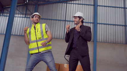 Warehouse worker and manager dancing in a large warehouse